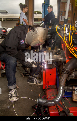 Ein teenboy bereitet sich auf Bogen Schweißnaht ein Motors zu unterstützen, in ein Highschool-Auto-Shop-Klasse in San Clemente, Kalifornien. Stockfoto