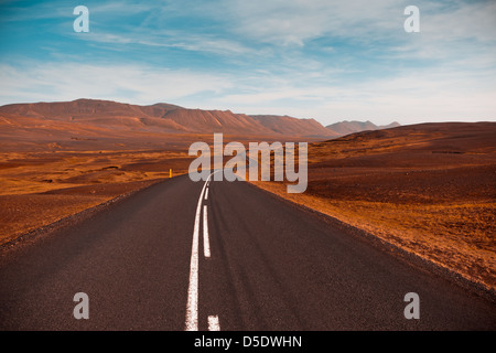 Autobahn durch trockenen Kies Lava Feld Landschaft unter einem blauen Sommerhimmel. Hochland von Central Island. Gefiltertes Bild Stockfoto