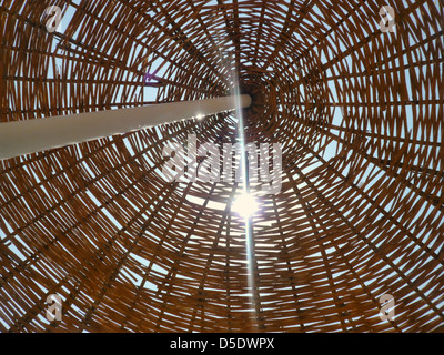 Sonne durch Wicker Strand Sonnenschirm Stockfoto