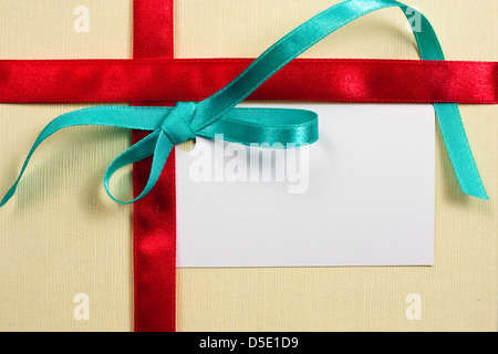 Leere Geschenkanhänger mit einer Schleife Rot Satinband gebunden. Stockfoto