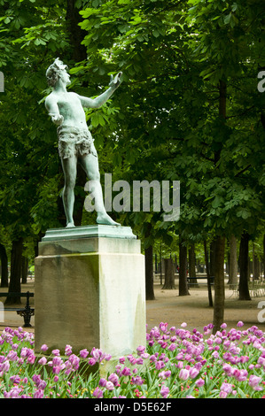 Frühlingsblumen umgeben die Bronzestatue L'acteur Grec von Arthur Bourgeois (1838-1886) im Jardin du Luxembourg, Paris, Frankreich Stockfoto