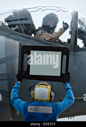 Eine USMC-Pilot, Marine Angriff Geschwader zugewiesen erhält Anweisungen von Flugdeck Personal vorher ausziehen 25. März 2013 auf amphibischer Angriff Schiff USS Boxer vor der Küste von Süd-Kalifornien. Stockfoto