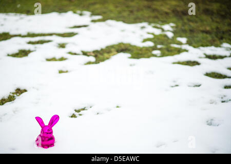 Ein rosa Osterhase aus Keramik gefertigt ist in bleibt der Schnee in einem Garten in Busbach, Deutschland, 30. März 2013 abgebildet. Foto: David Ebener Stockfoto