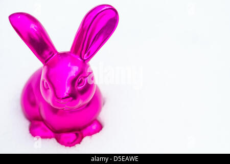 Ein rosa Osterhase aus Keramik gefertigt ist in bleibt der Schnee in einem Garten in Busbach, Deutschland, 30. März 2013 abgebildet. Foto: David Ebener Stockfoto