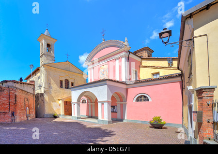 Zwei Kirchen nebeneinander auf kleinen gepflasterten Platz in Stadt Zentrum von Barolo im Piemont, Norditalien. Stockfoto