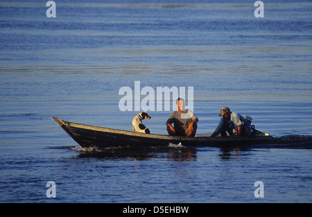 Zwei Männer und ein Hund Autofahren in ihren Einbaum am Fluss Rio Uatuma in der Nähe von Itapiranga Amazonas Brasilien Stockfoto