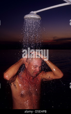 Ein Mann unter einer Dusche im Freien auf einem Hausboot auf dem Rio Uatuma River in der Nähe von Itapiranga Amazonas Brasilien Stockfoto