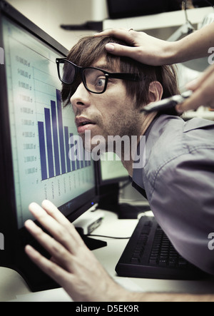 Büroangestellter gezwungen, härter zu arbeiten und härter Stockfoto