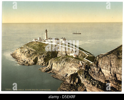 Blick auf den South Stack Lighthouse in Anglesey, Wales, auf einer Klippe nahe Holyhead. Es ist ein ikonisches maritimes Wahrzeichen, das Schiffe durch gefährliche Gewässer führt. Stockfoto