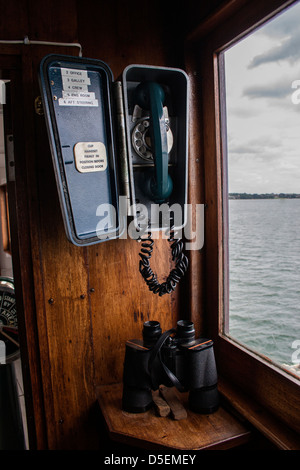 Ferngläser und Telefon auf Schiffs Brücke - Kommunikations-Konzept Stockfoto