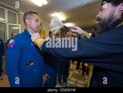 Expedition 35 NASA Flight Engineer Chris Cassidy, links, erhält der traditionelle Segnung von ein russisch-orthodoxer Priester im Hotel Kosmonauten vor seiner Markteinführung auf der Sojus-Rakete auf der internationalen Raumstation ISS am Weltraumbahnhof Baikonur 28. März 2013 in Baikonur, Kasachstan. Stockfoto