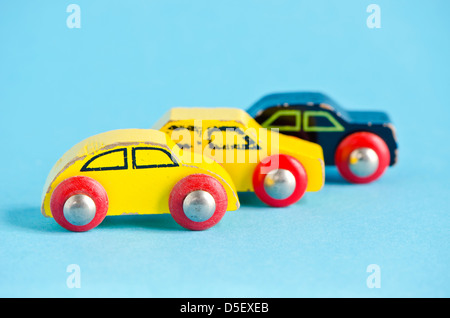 drei alte Holz- und bunte Auto Spielzeug am azurblauen Hintergrund Stockfoto
