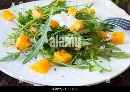 Salat mit Stücken von Kürbis und frischen Rucola, grün Stockfoto