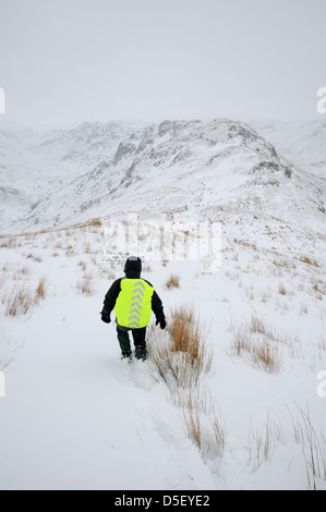 Walker im Tiefschnee auf Spitze Felsen (der Löwe und das Lamm) in der Nähe von Grasmere im Winter im englischen Lake District Stockfoto