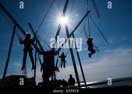 Aberystwyth Wales UK, Ostern Sonntag, 31. März 2013. Kinder freuen sich über die Frühlingssonne auf die Bunjee-Trampolin auf Aberystwyth Promenade zu spielen. Anhaltende östlich windet Mittel, das dies der kälteste März 1962 wurde, und Temperaturen werden eingestellt, um unter dem Durchschnitt für die erste Woche im April Foto © Keith Morris Stockfoto