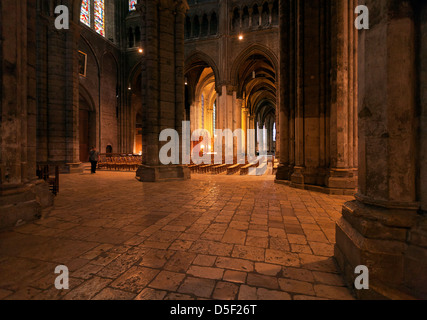 Innenraum der Kathedrale Notre Dame, Chartres, Frankreich mit einer einsamen Person (Bewegungsunschärfe) mit warmem goldenem Licht im Kirchenschiff Stockfoto