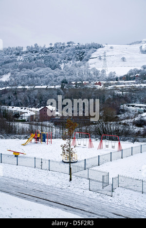 Schneebedeckte Aberfan mit Kinderspielplatz im Vordergrund Stockfoto