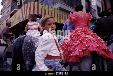 Spanische Dorfbewohner in traditionellen Kostümen besetzten Pferde während eines lokalen feria-Festivals in der andalusischen Autonomen Gemeinde in Südspanien Stockfoto