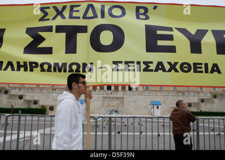 Athen, Griechenland. 31. März 2013.  Ein Demonstrant hält einen Banner, der '' Nein zu Euro - tot Stornierung jetzt '' während einer Anti-Sparmaßnahmen Kundgebung vor dem Parlament belohnt. Einige hundert Demonstranten blockierten die Straße vor dem Parlamentsgebäude Protest gegen Sparmaßnahmen und der Einführung der Maßnahmen nach Zypern der EU. (Bild Kredit: Kredit: Aristidis Vafeiadakis/ZUMAPRESS.com/Alamy Live-Nachrichten) Stockfoto