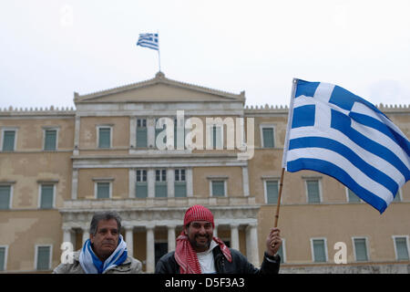 Athen, Griechenland. 31. März 2013.  Ein Demonstrant hält eine griechische Flagge, während eine Anti-Sparmaßnahmen-Kundgebung vor dem Parlament. Einige hundert Demonstranten blockierten die Straße vor dem Parlamentsgebäude Protest gegen Sparmaßnahmen und der Einführung der Maßnahmen nach Zypern der EU. (Bild Kredit: Kredit: Aristidis Vafeiadakis/ZUMAPRESS.com/Alamy Live-Nachrichten) Stockfoto