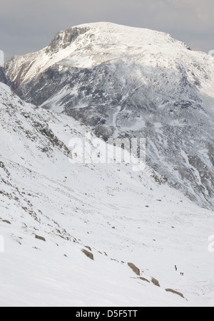 Porträt des großen Giebel von Esk Hause im Winter im englischen Lake District. Wanderer im Vordergrund für Skala Stockfoto