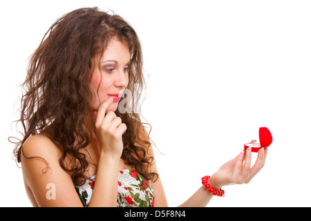 Attraktive junge Frau öffnet ein Geschenk und ist erstaunt über einen Verlobungsring Stockfoto