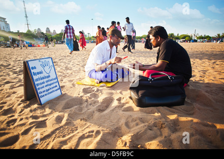 Wahrsagerin lesen Mannes Palmen am Strand, Chennai, Tamil Nadu, Indien Stockfoto