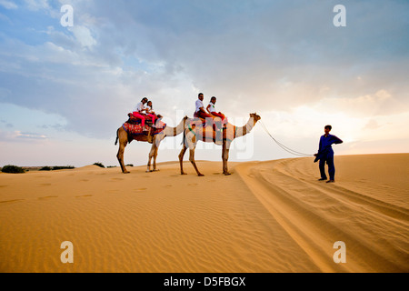 Touristen genießen die Kamel-Safari in der Wüste Thar-Wüste, Jaisalmer, Rajasthan, Indien Stockfoto