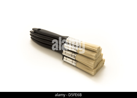 Vier schwarze neue Pinsel in verschiedenen Größen übereinander gestapelt Stockfoto