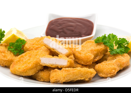 Chicken Nuggets mit Zitronenscheiben und ein Grill-Dip, serviert auf einen Teller und verzehrfertige - weißen Hintergrund Stockfoto