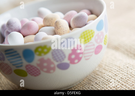 Eine Schüssel mit Mini Ostereier, auf braunem strukturiertem Hintergrund Stockfoto