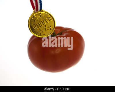 Tomate mit Goldmedaille Sieger Anhänger an einem hölzernen Hintergrund Stockfoto