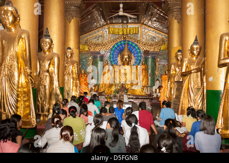 Gläubige beten im Inneren einen Betsaal an der Shwedagon-Pagode, Yangon (Rangoon), Myanmar (Burma) Stockfoto