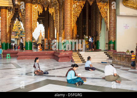 Gläubige beten außerhalb einen Betsaal an der Shwedagon-Pagode, Yangon (Rangoon), Myanmar (Burma) Stockfoto