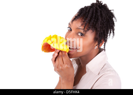 Junge glücklich schwarz / afroamerikanische Frau essen frische Mango isoliert auf weißem Hintergrund Stockfoto