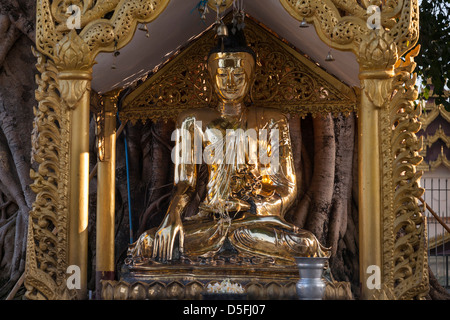 Eine Buddha-Statue in einen Betsaal an der Shwedagon-Pagode, Yangon (Rangoon), Myanmar (Burma) Stockfoto