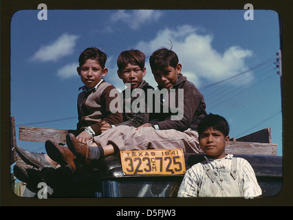 Dieses Foto zeigt Jungen, die in einem Arbeitslager der Farm Security Administration (FSA) in Robstown (Texas) auf einem Lastwagen sitzen, aufgenommen 1942. Das Lager war Teil der Bemühungen, Wanderarbeiter während der Großen Depression zu unterstützen. Stockfoto