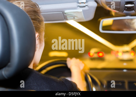 Junge Frau fährt Trog Tunnel mit ihrem Auto auf Autobahn Stockfoto