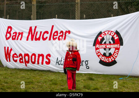 Aldermaston, UK. 1. April 2013.  Ein Kind geht vor ein "Verbot von Atomwaffen" Banner an der Aldermaston Umzäunung angebracht. Kampagne für Nuclear Disarmament (CND) Protest der atomaren Waffen Einrichtung (AWE) Website in Aldermaston, Berkshire. CND gegen Großbritanniens Trident Atomwaffen System markieren wollen und plant, es zu ersetzen. Bildnachweis: Martyn Wheatley/Alamy Live-Nachrichten Stockfoto