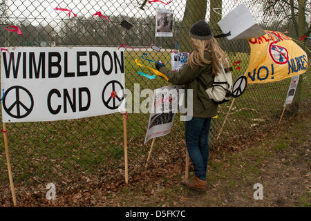 Aldermaston, UK. 1. April 2013.  Aktivistin bindet eine Beschriftung der Umzäunung, Campaign for Nuclear Disarmament (CND) Protest der atomaren Waffen Einrichtung (AWE) Website in Aldermaston, Berkshire. CND gegen Großbritanniens Trident Atomwaffen System markieren wollen und plant, es zu ersetzen. Bildnachweis: Martyn Wheatley/Alamy Live-Nachrichten Stockfoto