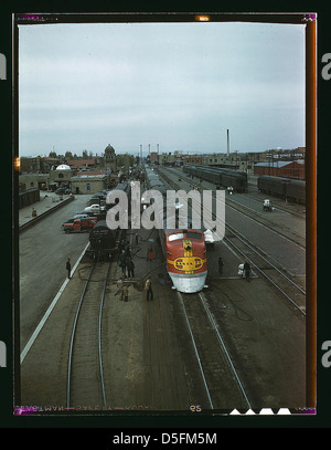Ein Foto von 1943, auf dem der Santa Fe Super Chief Zug im Depot in Albuquerque, New Mexico, bedient wird. Der Diesel-Streamliner wird im Rahmen der planmäßigen Wartung schnell gewartet. Stockfoto