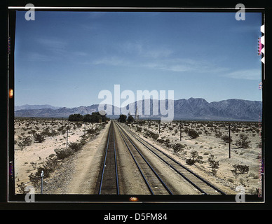 Dieses Foto zeigt die Santa Fe Railway-Linie, die von Cadiz, Kalifornien, abfährt und eine Anschlussstelle mit einer Nebenstrecke nach Phoenix, Arizona, verbindet. Das Bild zeigt die riesige Wüstenlandschaft im Hintergrund. Stockfoto