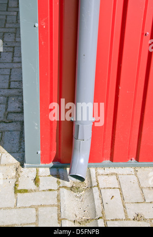 Abfluss der Regenrinne am neuen Haus rot Metallwand Stockfoto