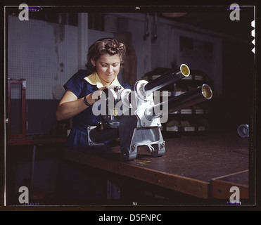 Eine junge Mitarbeiterin von North American Aviation, Incorporated, arbeitet über den Fahrwerksmechanismus eines P-51 Kampfflugzeugs, Inglewood, Kalifornien. Der Mechanismus ähnelt einer kleinen Kanone (LOC) Stockfoto