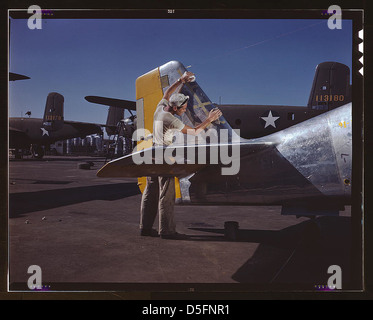 Auf der nordamerikanischen Montagelinie im Freien reinigt ein Maler den Heckbereich eines P-51-Kämpfers, bevor er die olivgrüne Tarnung der US-Armee, N[orth] A[merican] Aviation, Inc., Inglewood, Kalifornien, sprüht. (LOC) Stockfoto