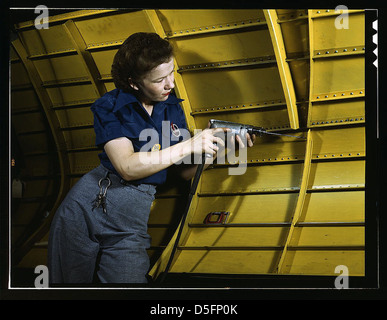Ein Foto aus dem Jahr 1943, das eine Frau zeigt, die während des Zweiten Weltkriegs in der Flugzeugfabrik Vultee in Nashville, Tennessee, eine Handbohrmaschine an einem Tauchbomber „Vengeance“ bedient. Dieses Bild zeigt die Rolle der Frauen in der Kriegszeit. Stockfoto