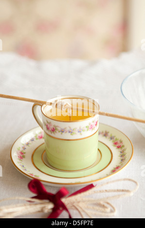 Tee Tasse Kerzenherstellung Schritt für Schritt 3. Aynsley Tasse Tee/Kaffee mit geschmolzenem Wachs und Docht Stockfoto