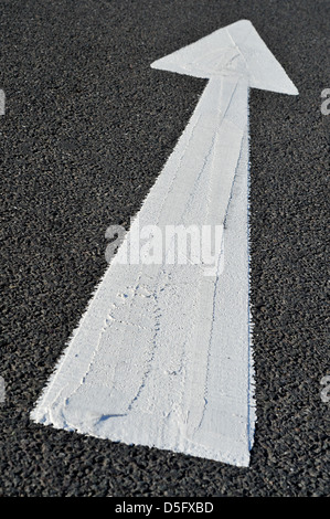 Weißer Pfeil auf Straße Richtung Oberfläche zeigen. Stockfoto