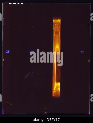 Ein Arbeiter wird gesehen, wie er losen Koks aus den Öfen der Great Lakes Steel Corporation in Detroit, Michigan, entfernt. Dieses Foto aus den 1940er Jahren fängt die Intensität und Details der Stahlproduktion während des Zweiten Weltkriegs ein Stockfoto