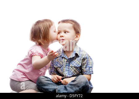 Kleines Mädchen küssen ihr älteren Bruder auf die Wange - isoliert Stockfoto